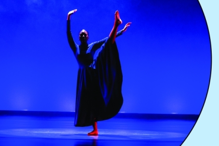 Dancer in blue light performing; photo in circle over light blue background with red spark.