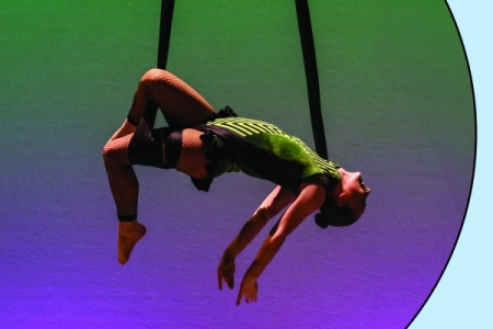 Aerialist dancer performing in green and purple light; photo in circle over blue background with red spark.